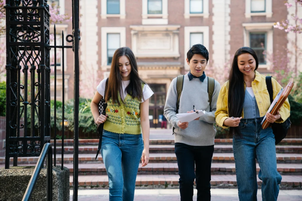 Three young people walking together down a city street, engaged in conversation and enjoying their surroundings.